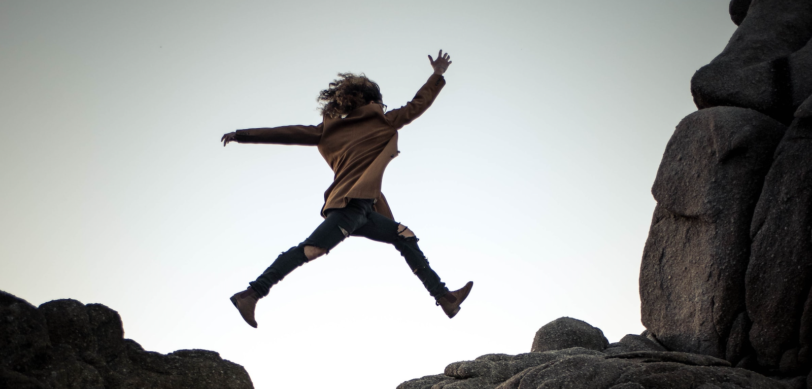 person jumping over a chasm